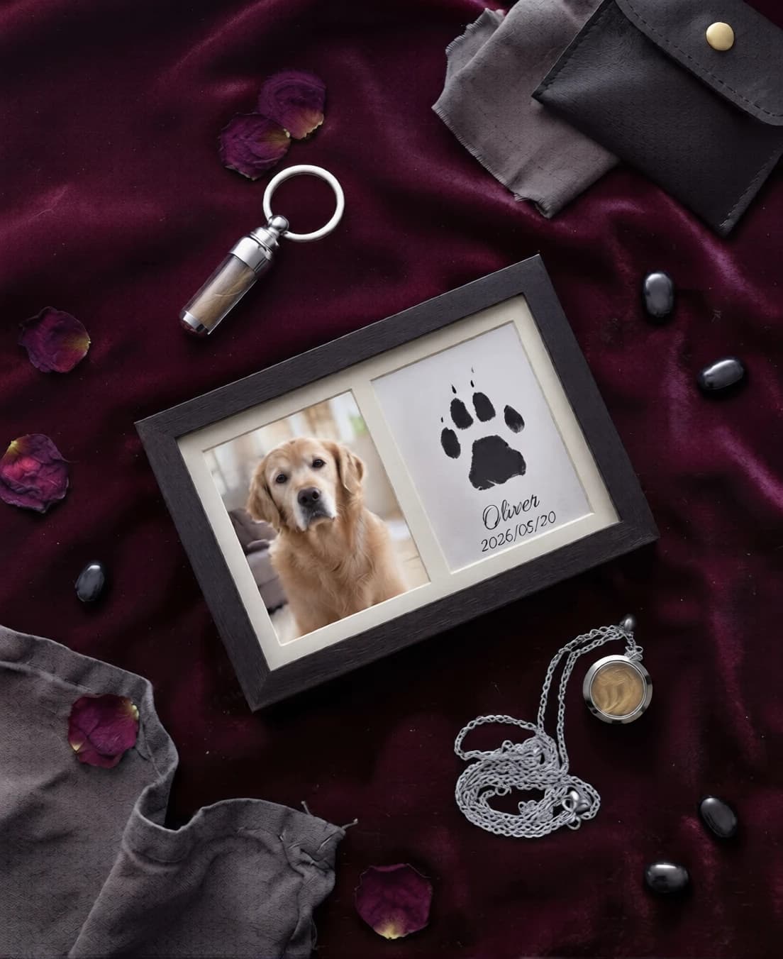 The kit laid out on bordeaux velvet: a double frame with a golden retriever's photo and paw print, a keychain vial, a locket necklace and a black pouch